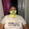 Keisha wearing a yellow face mask that says "Trust your dopeness" and a t-shirt that says Black Disabled Lives Matter.