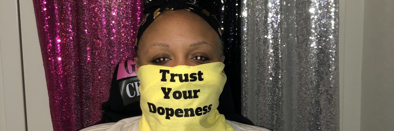 My Experience Living as a Black Disabled Woman Keisha wearing a yellow face mask that says "Trust your dopeness" and a t-shirt that says Black Disabled Lives Matter.