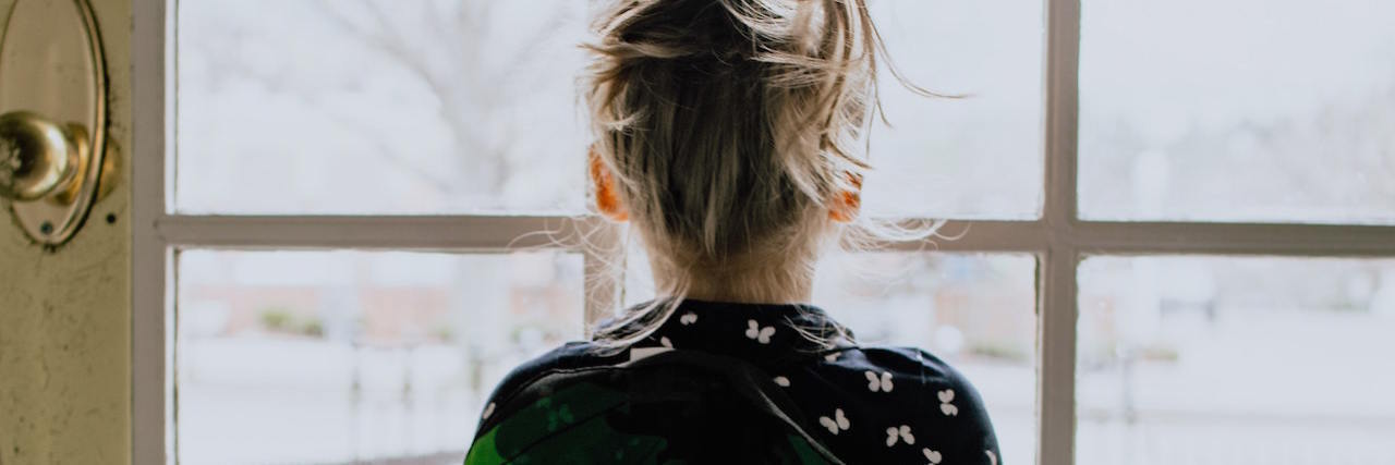 Growing Up in a Home With Two Abusive Parents A little girl staring out a window