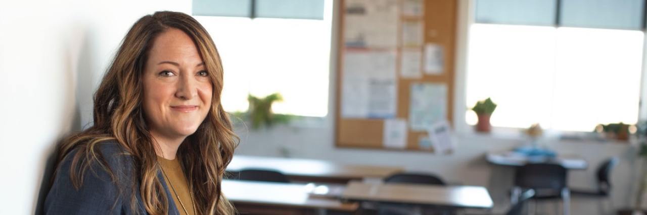 Business woman looking directly at camera in front of classroom