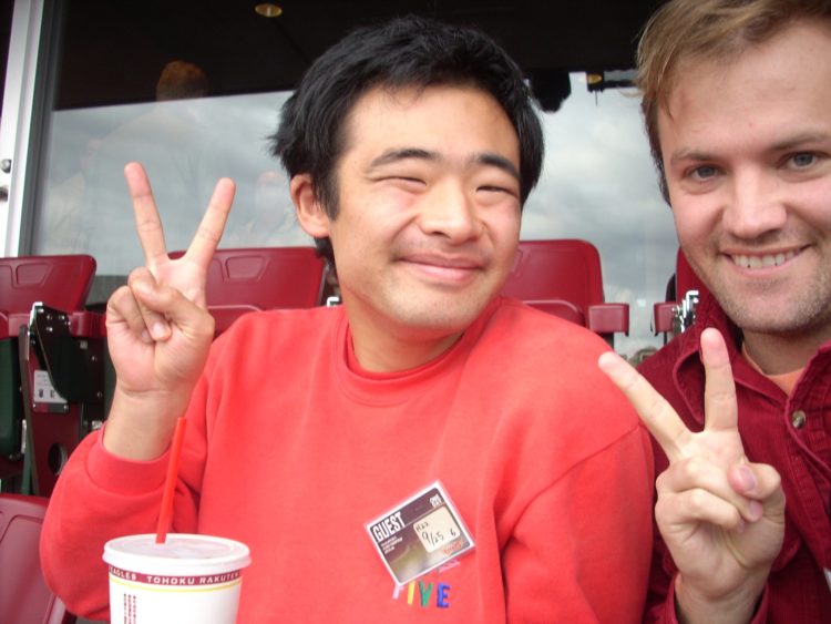 Contributor with his student, both making peace signs