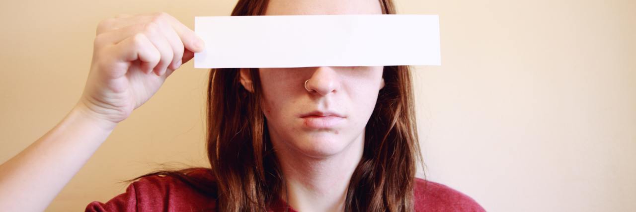 I Feel Like My Depression Disguises Itself photo of young woman hiding her eyes with a rectangle of paper