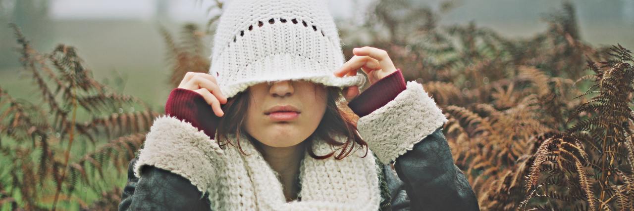 14 Signs You Have a Fearful-Avoidant Attachment Style A woman covering her head with her hat