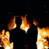 Silhouette of man and woman in front of a fire
