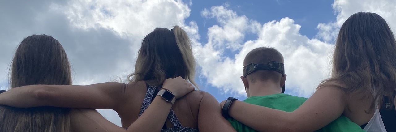 Why Time Is the Gift My Son With Down Syndrome Needs Most Wil linking arms with his sisters and mom.