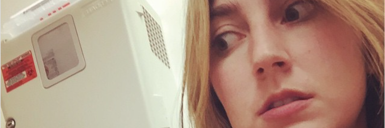 Finding Spoonie Support With Colitis and Inflammatory Bowel Disease The author sitting in a doctor's office, with her hand under her chin, looking worried/scared