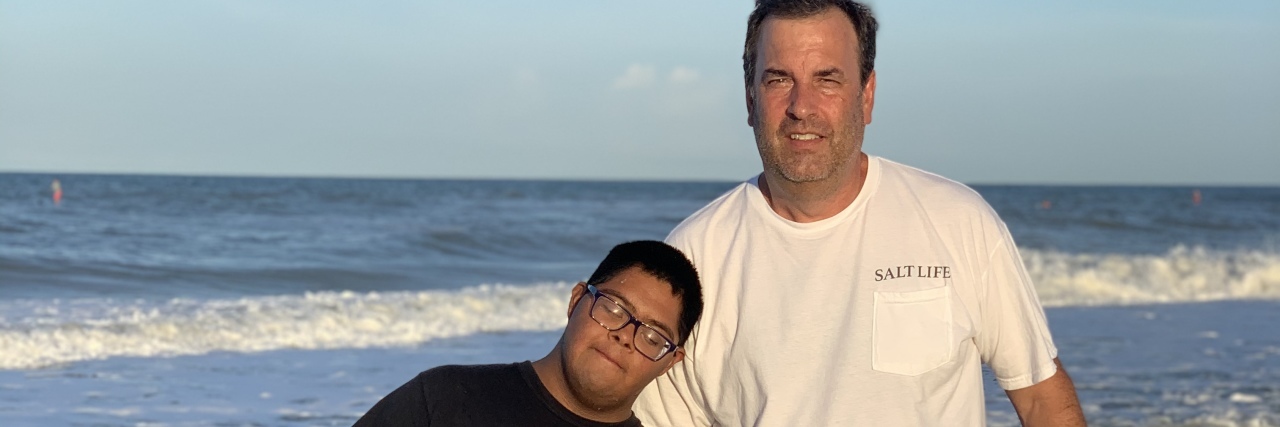 Michelle's son and his dad with their dog on the beach.