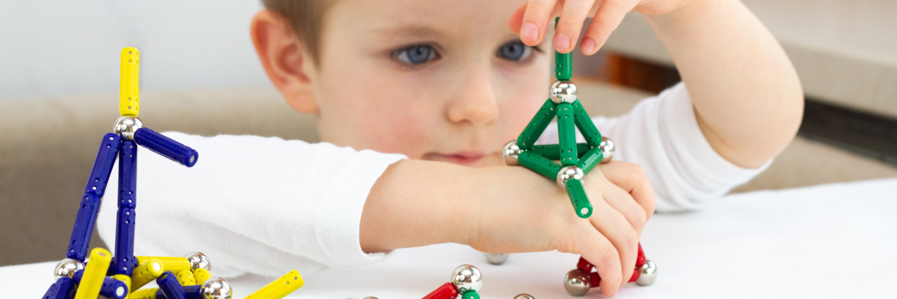 Why Psycho-Educational Assessments Are Essential for Autistic Students Boy playing with magnet toys.