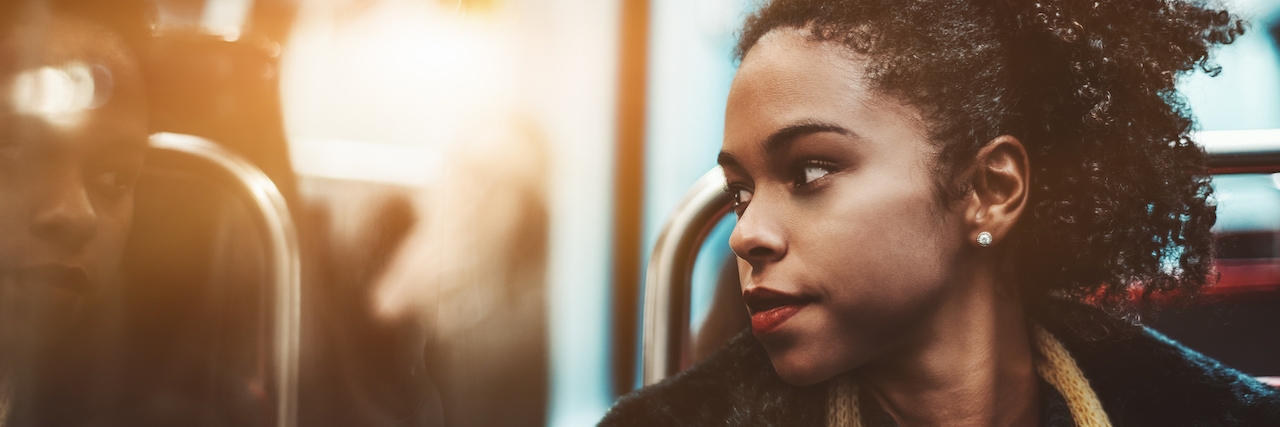 15 'Red Flags' People Noticed the First Time They Were Manic young woman pensively looking outside the carriage window while sitting in a metro train
