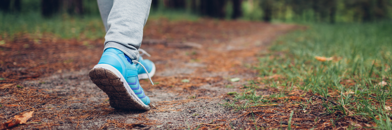 My Problem With 'Steptember' as an Adult With Cerebral Palsy Woman walking in spring forest.