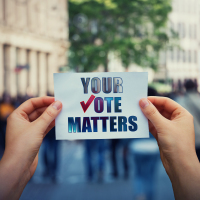 Hands hold a paper sheet with the message "Your vote matters."