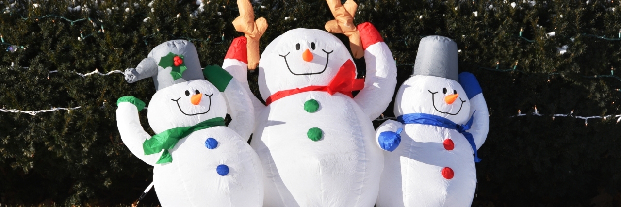 Tips for Choosing Autism-Friendly Holiday Decorations Three inflatable snowmen in the front yard.