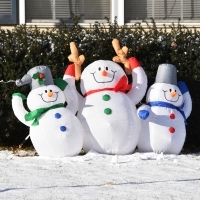 Three inflatable snowmen in the front yard.