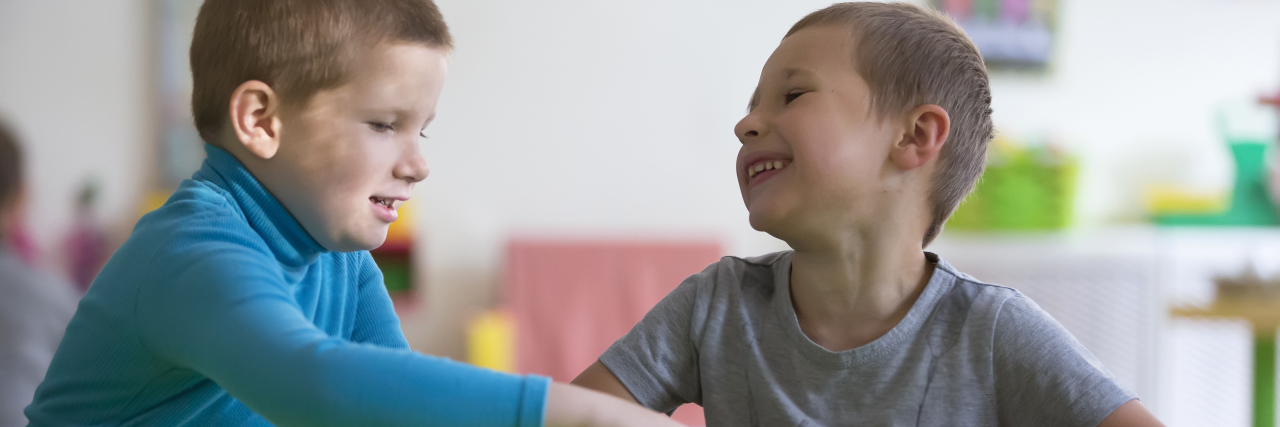 How to Support Siblings of a Child on the Autism Spectrum Brothers playing with toys at table.