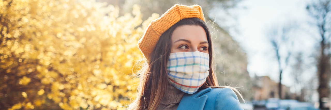 Woman wears reusable mask outdoors during coronavirus covid-19 pandemic.