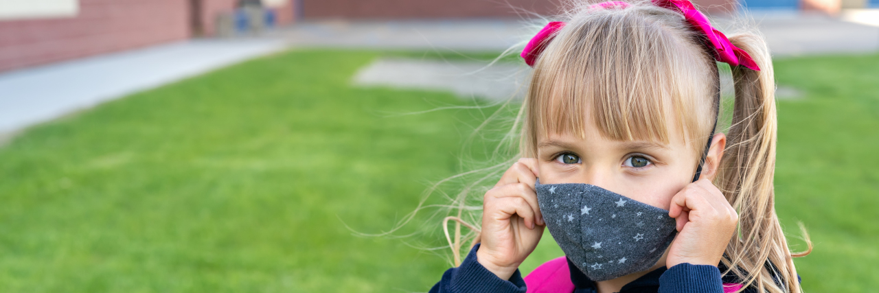 Coping With the Stress of Back-to-School During COVID-19 Girl wearing a mask and school backpack.
