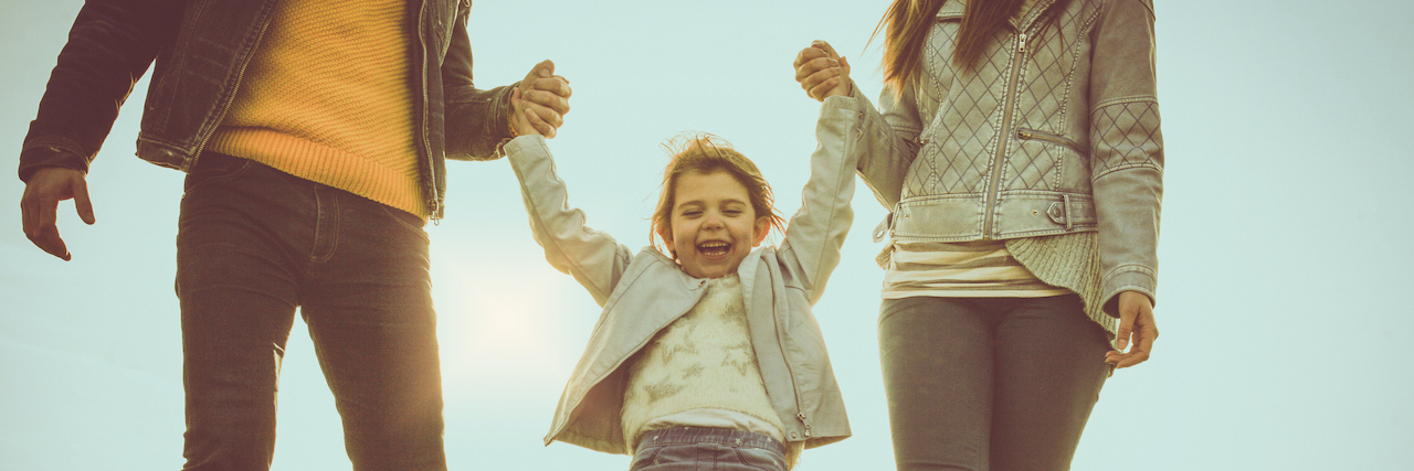 What Parents Say to Children Impacts Their Mental Health Happy parents playing with their daughter in the park.