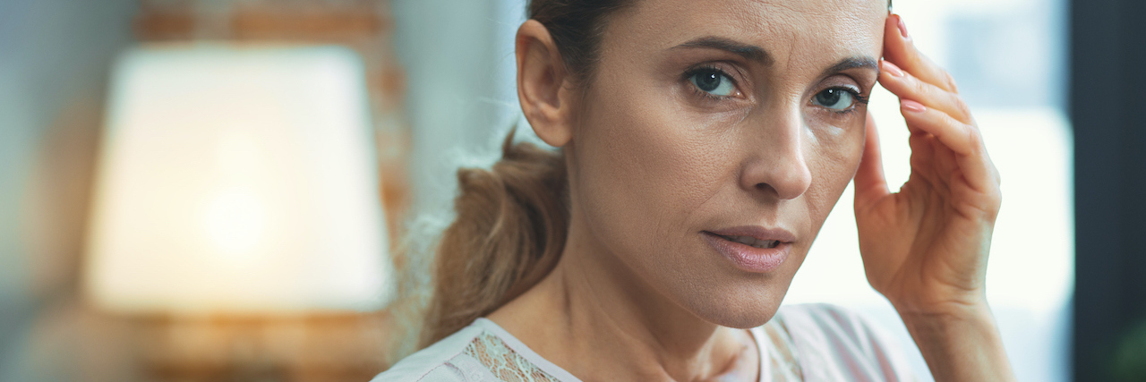 Using the Splat System to Tell Others About Your Pain A woman looking serious with her fingers on her temple