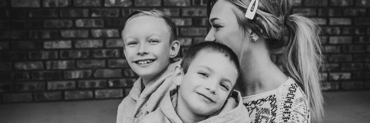 Consequences of Getting Hysterectomy for Endometriosis A black and white portrait of the author sitting with her two boys in her lap