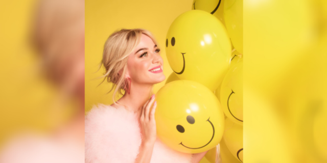 photo of Katy Perry posing with yellow balloons with smiling faces