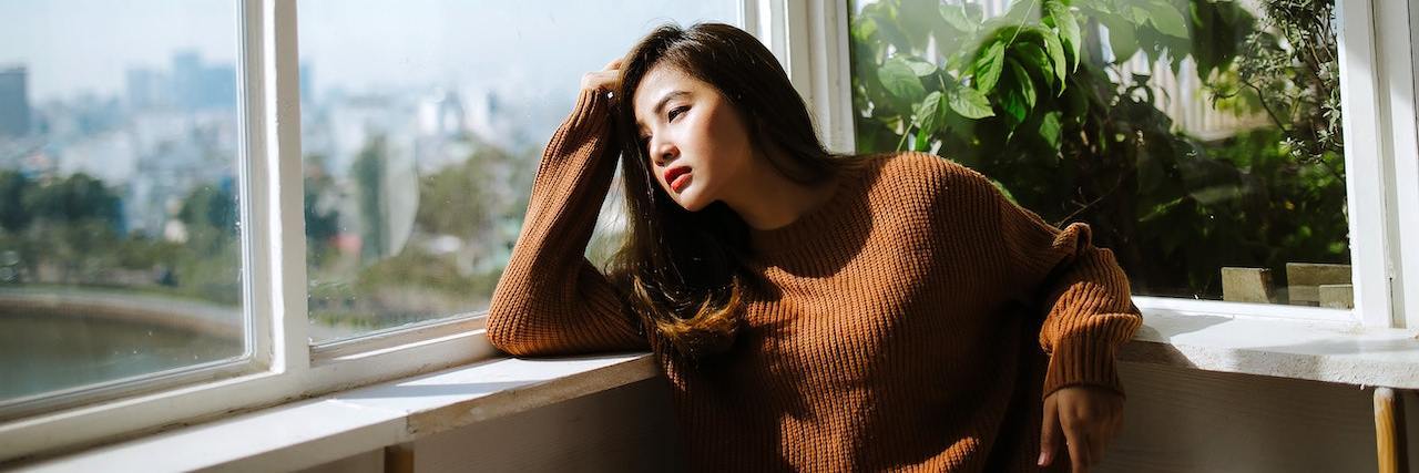 20 Things People With Fibromyalgia Need on a Bad Day A woman looking out a window