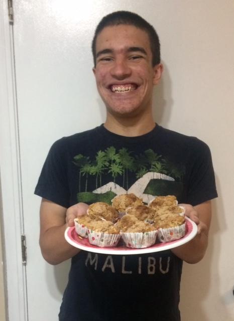 Dominic holding a plate of apple muffins.