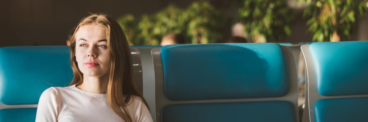 How I'm Changing My 'What If' Anxiety Thinking Patterns photo of woman sitting on blue public seats thinking