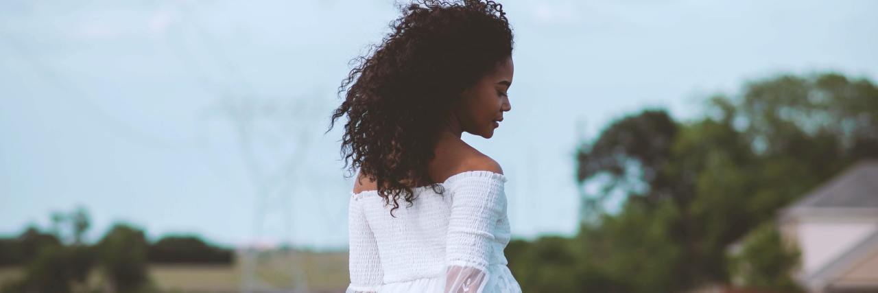 How To Protect Your Mental Health After Losing a Job To COVID-19 photo of a woman in a white dress standing in a field