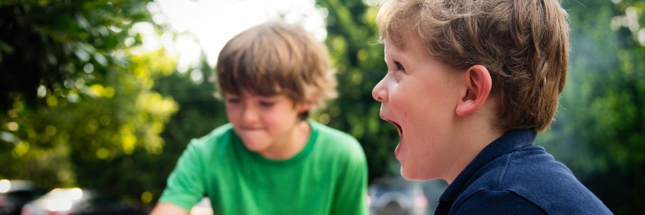 Two boys happily playing side by side in the yard