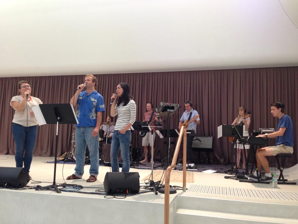 photo of the contributor singing at church on a white stage