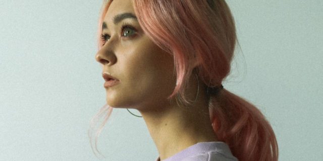 photo of woman with pink hair looking off to the distance