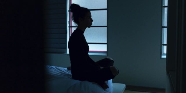 This Psych Nurse’s Belief Shows Why We Need to Destroy Eating Disorder Stigma photo of a woman silhouetted against window while sitting on bed in bare room
