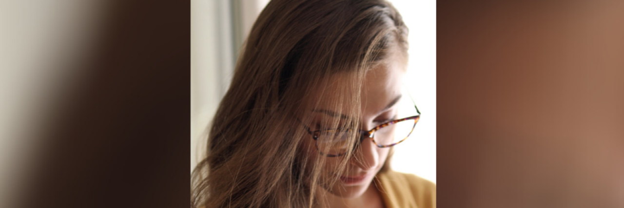 When Bipolar Disorder Makes Life Changes a Challenge Woman wearing glasses and looking downwards