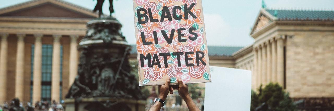 Daniel Prude Killed by Police After Psychiatric Hospital Release Man holds up a Black Lives Matter sign in a crowd of protestors