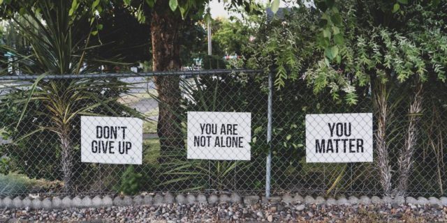 Signs saying "Don't give up," "You are not alone" and "You Matter"