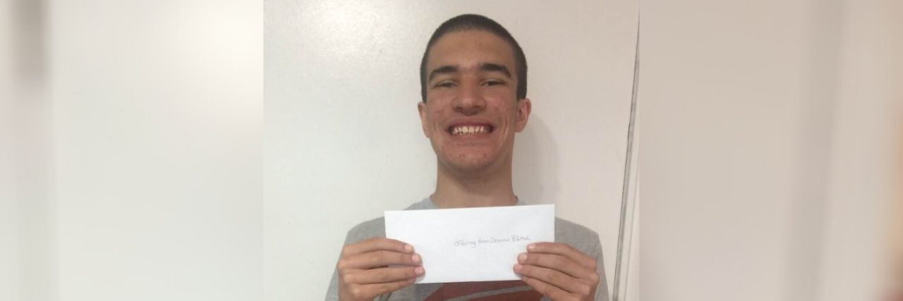 Teaching My Son on the Autism Spectrum to Manage Money Dominic holding his church offering envelope.