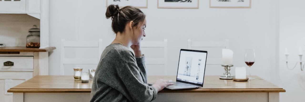 Why I've Struggled With Virtual Therapy During COVID-19 photo of woman sitting at a table with her laptop
