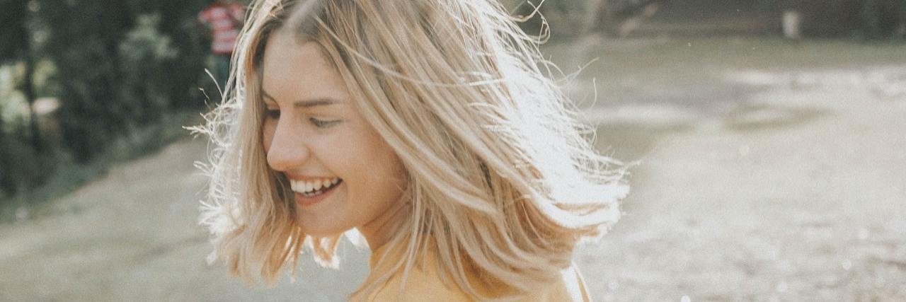 5 Good Traits of People With Borderline Personality Disorder A woman outside smiling and looking over her shoulder