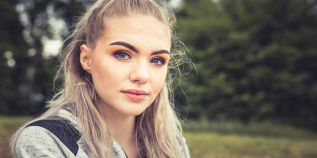 The Aspect of Suicidality That Suicide Prevention Campaigns Are Missing photo of blonde woman looking into camera with serious expression