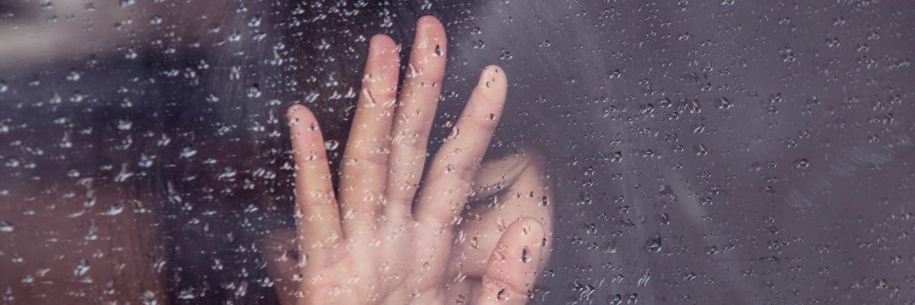 How Small Triggers Can Cause a Breakdown From Repressed Trauma Woman leaning on window with rain on it
