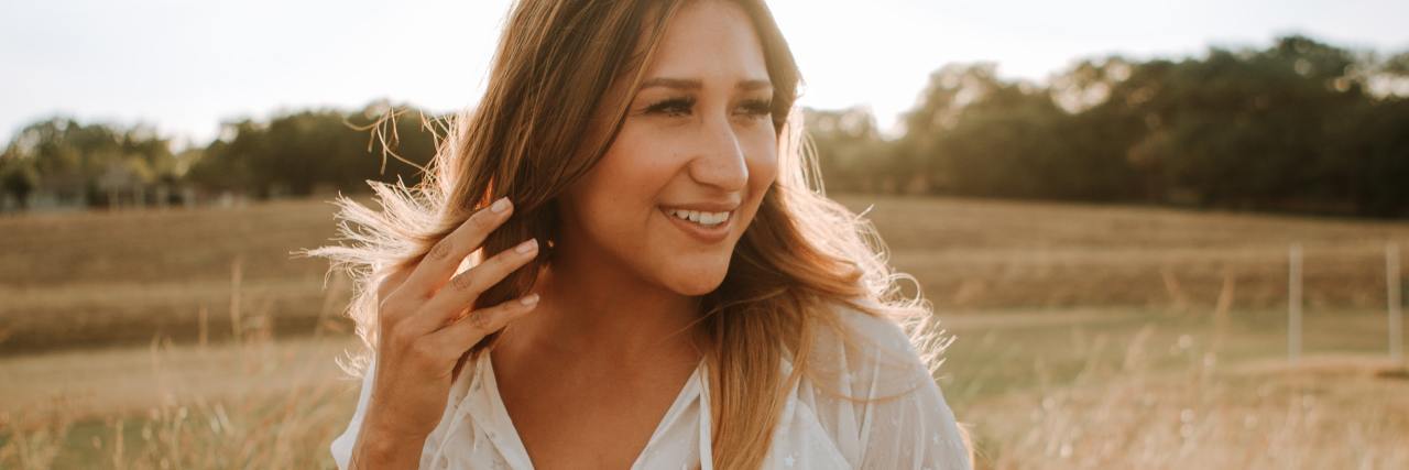 Celebrating My Survival Journey on World Suicide Prevention Day photo of woman smiling in a field at sunset