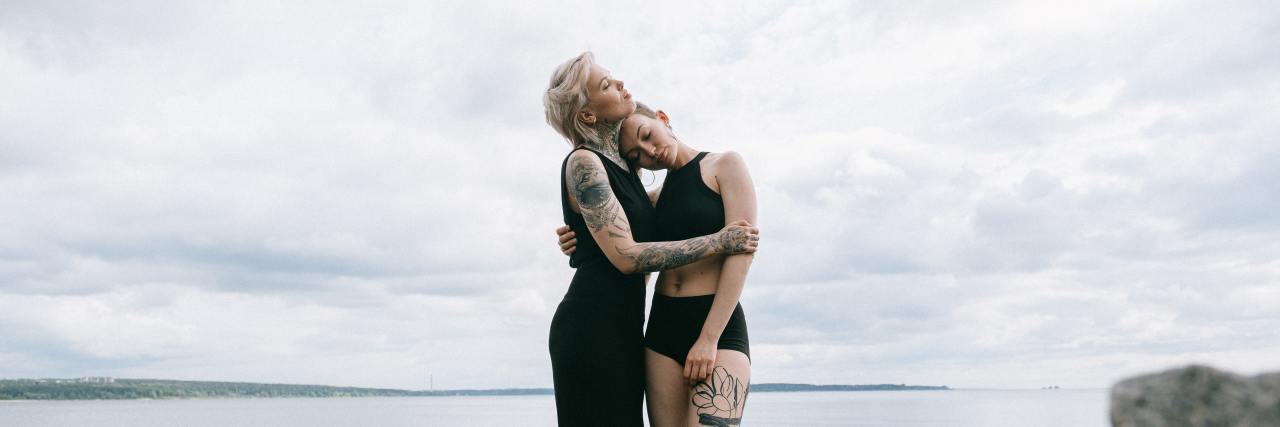How Human Connection Affects Our Perception of Chronic Pain Two female friends or lovers embracing.