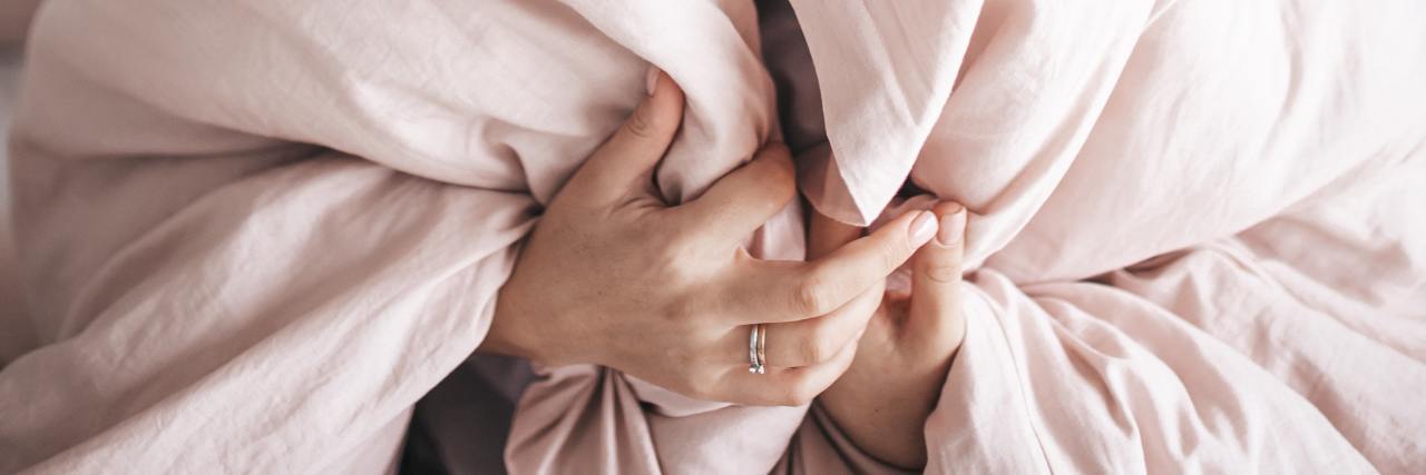 Self-Care Plans vs Safety Plan (and Why You Should Have Both) Woman cozy wrapped up in a blanket