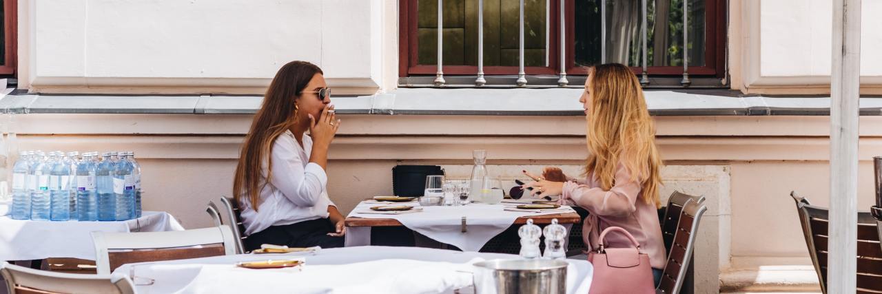 photo of two women talking over a table in a restairant