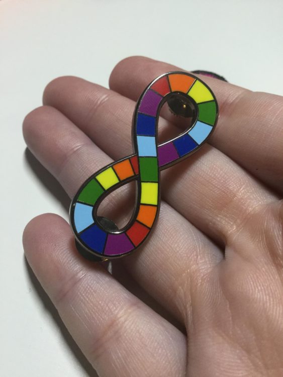 Enamel neurodiversity pride pin, an infinity symbol with the rainbow colors on it