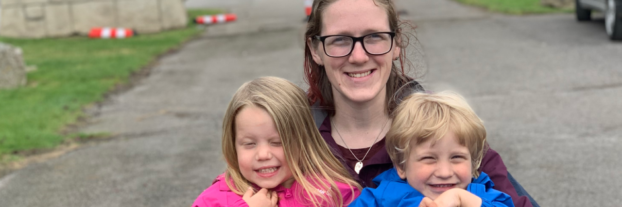 Pip holding her son and daughter on her lap.