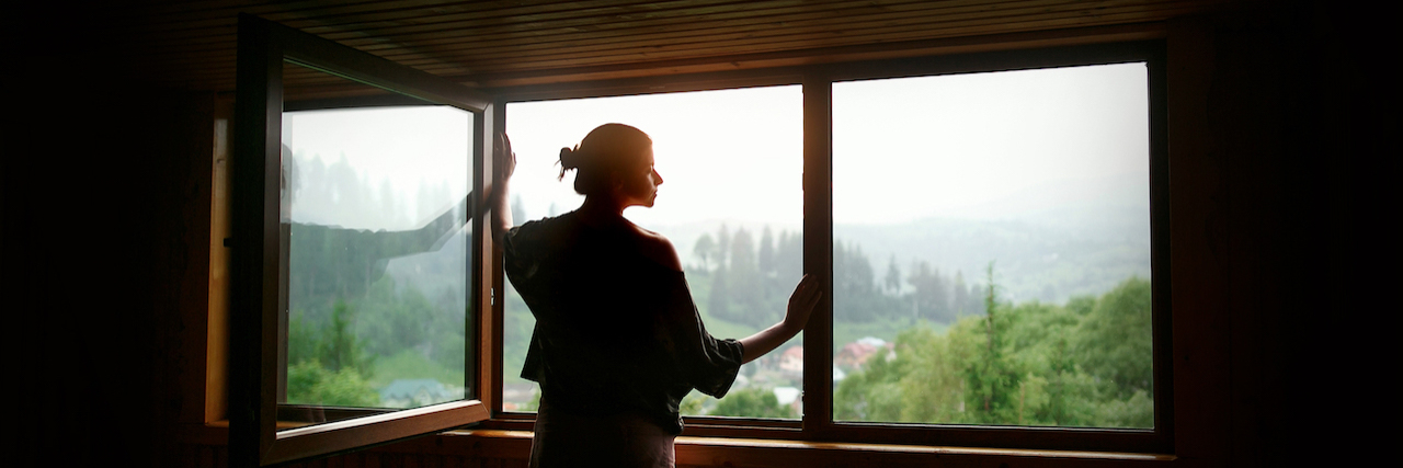 Silhouette of woman inside cabin window