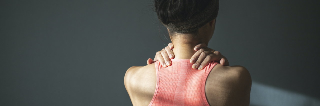 What Life Is Like With Complex Regional Pain Syndrome A woman holding her shoulders as if in pain