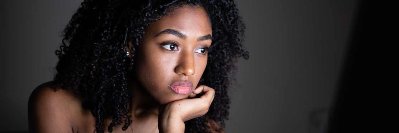 What I Realized About My Own Physical Scars After Watching Netflix's 'Skin Decisions' close-up of a young Black woman holding a remote control, pointed at a tv