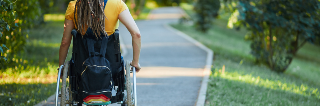 Young woman wheelchair user on an outdoor trail.